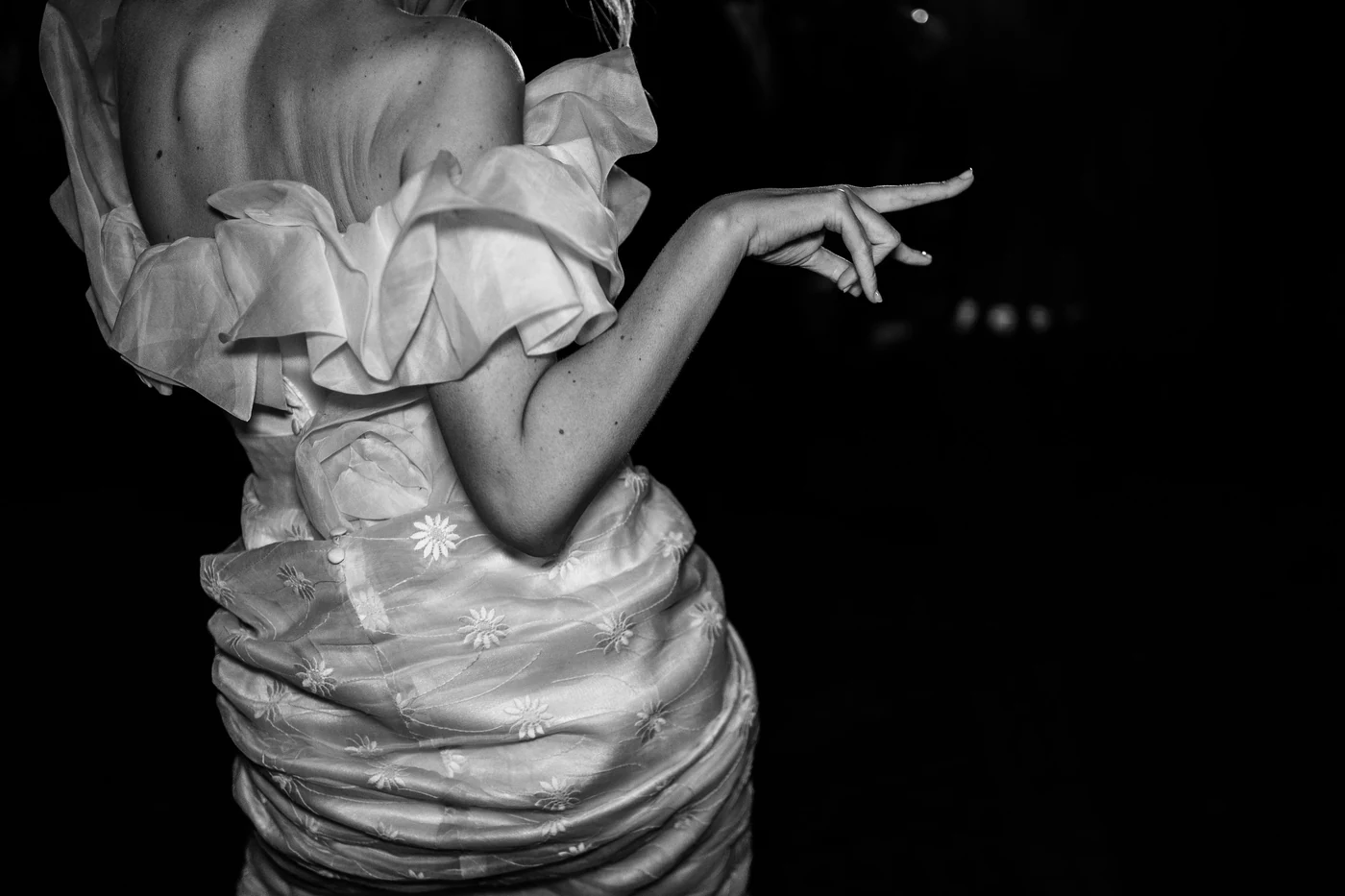 Bride in a ruffled dress dancing at the party, black and white photo