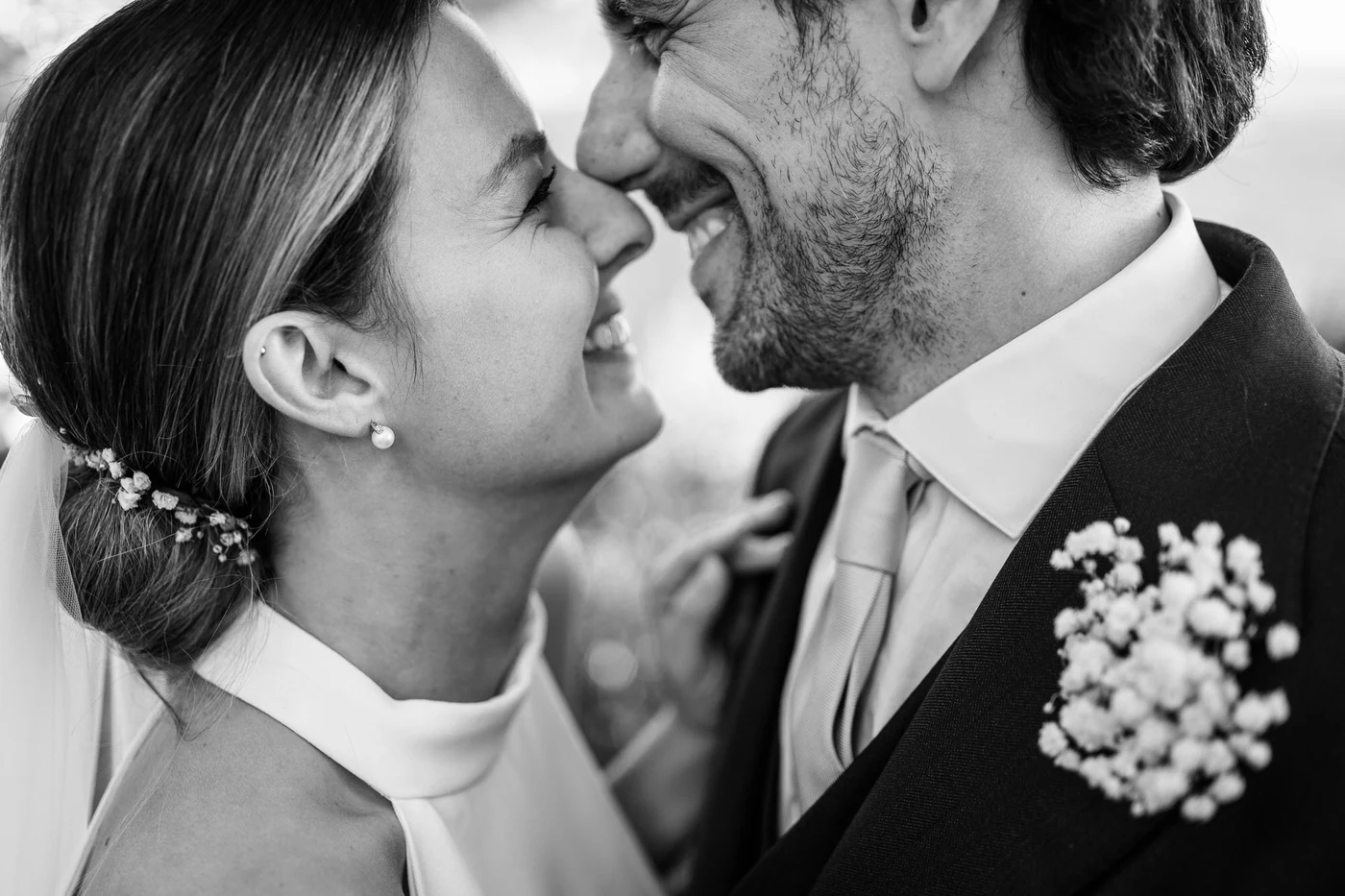 The couple smiling nose to nose, in black and white