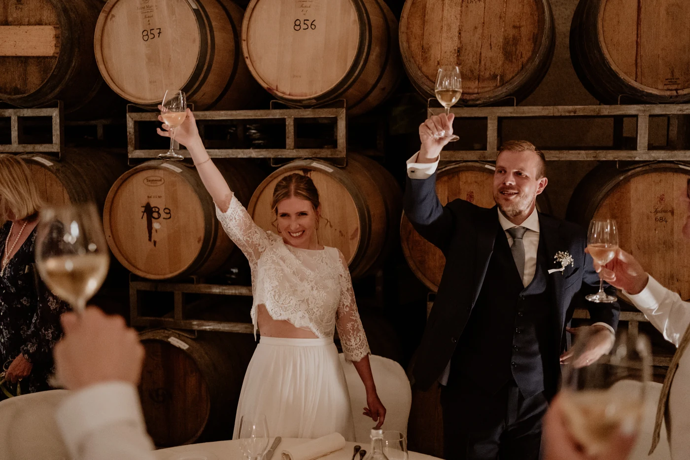 The couple toasting among the barrels in the Villa Sparina wine cellar, wedding in Piedmont