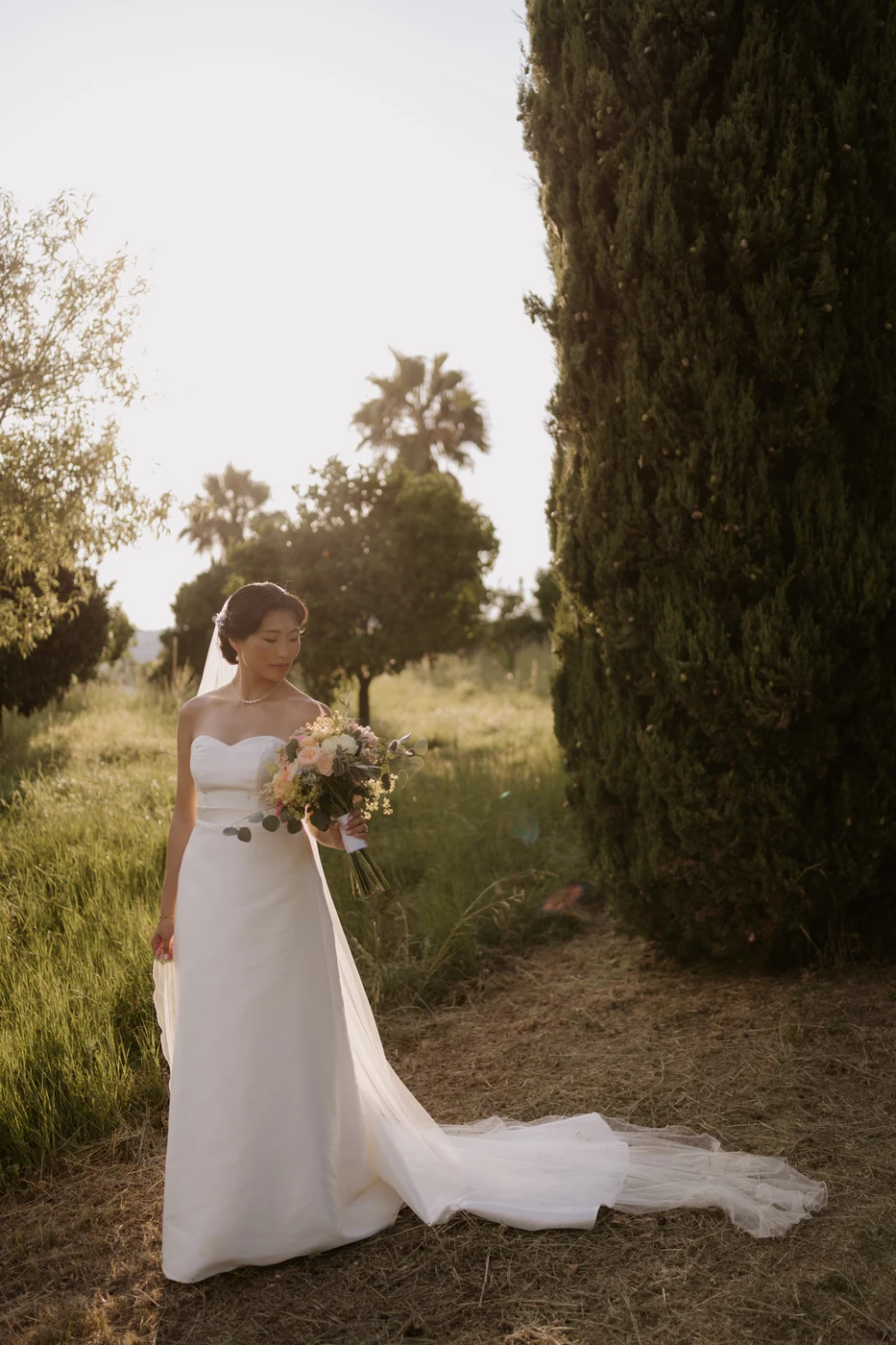 Sposa con il bouquet tra i cipressi dell'Orangerie di Villa Lagorio