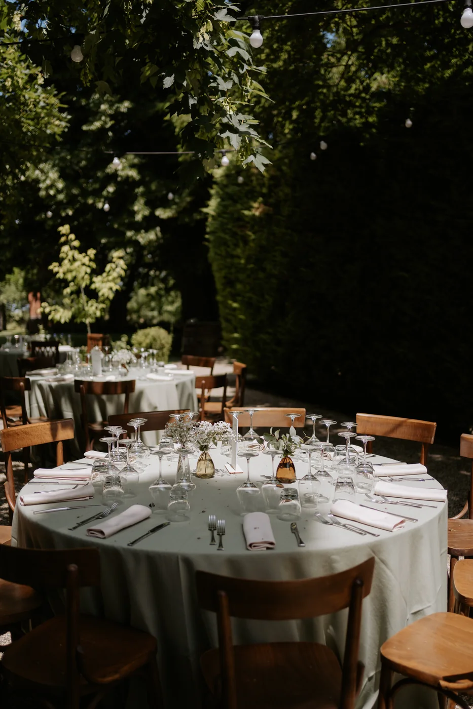 Round table set in the garden of Villa Delfini