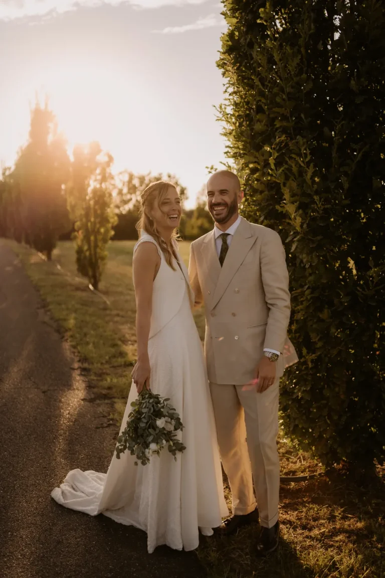 The couple along a tree lined path at sunset