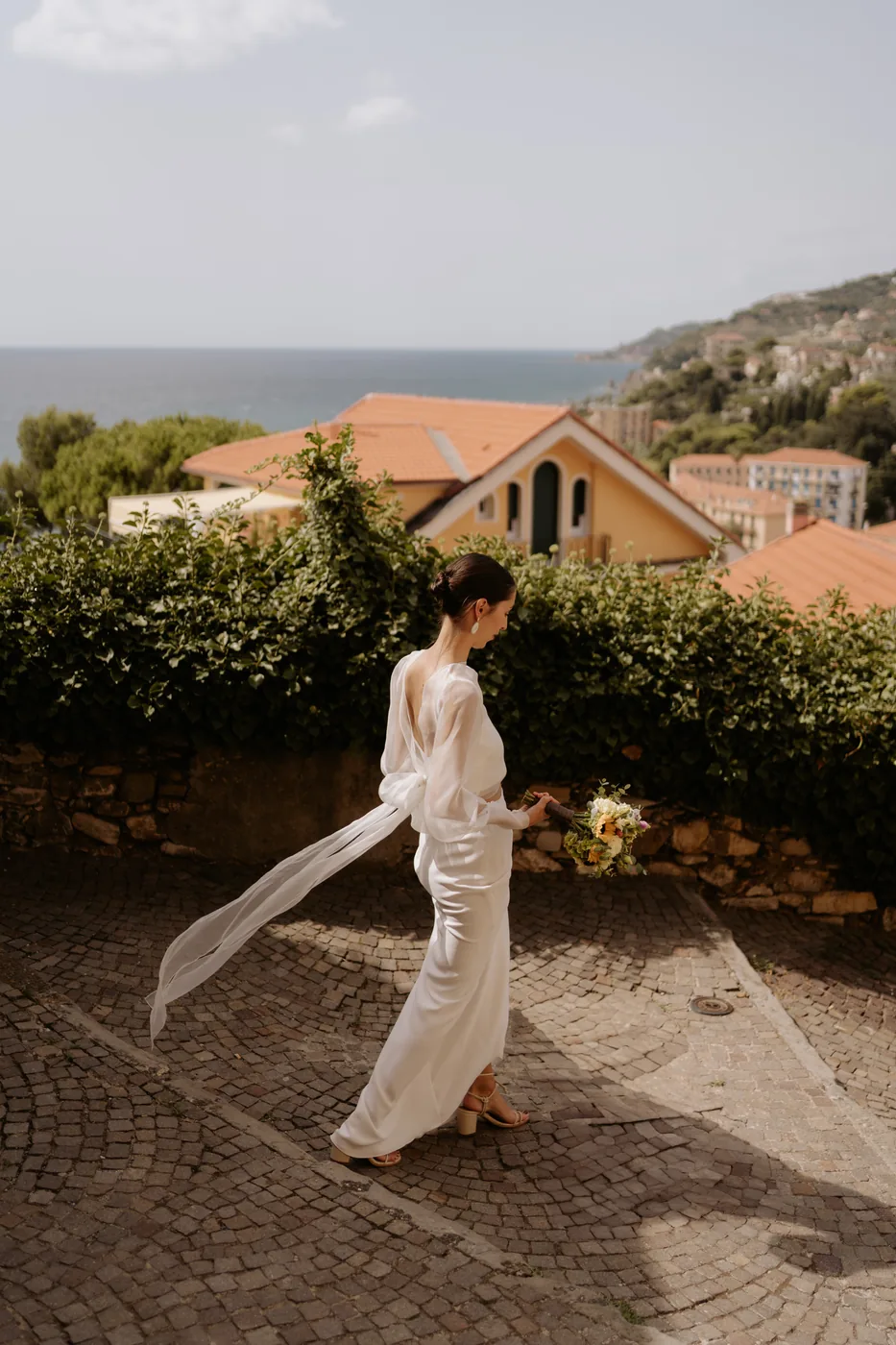 The bride's veil flying in the wind in the little square overlooking the sea