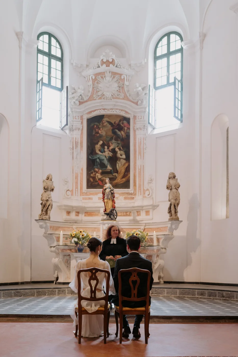 The couple seated in front of the chapel's baroque altar