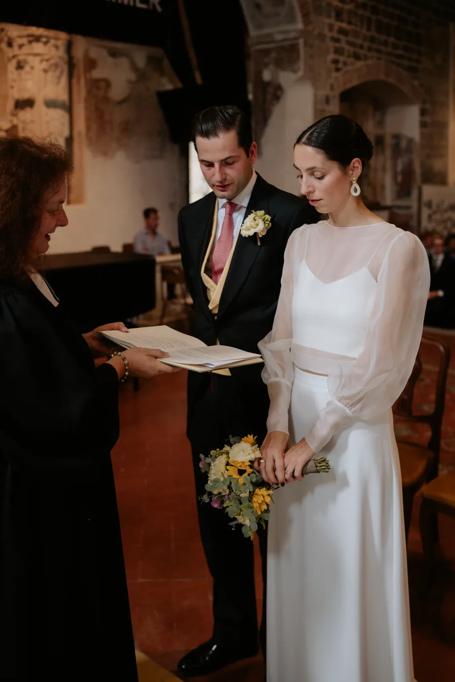 The couple standing during the ceremony reading