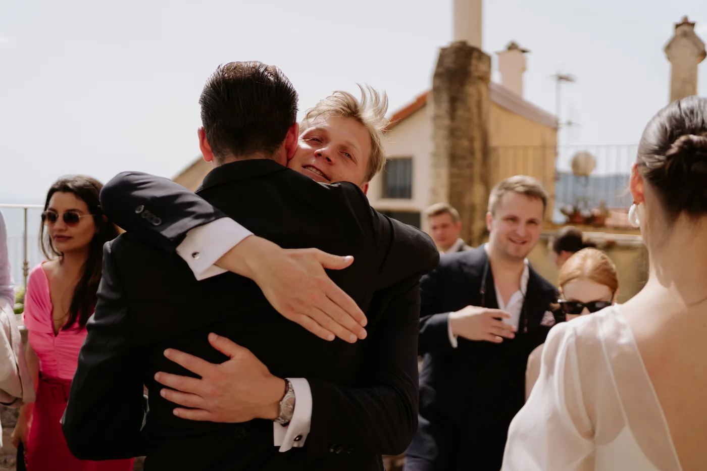 The groom hugging a guest after the ceremony