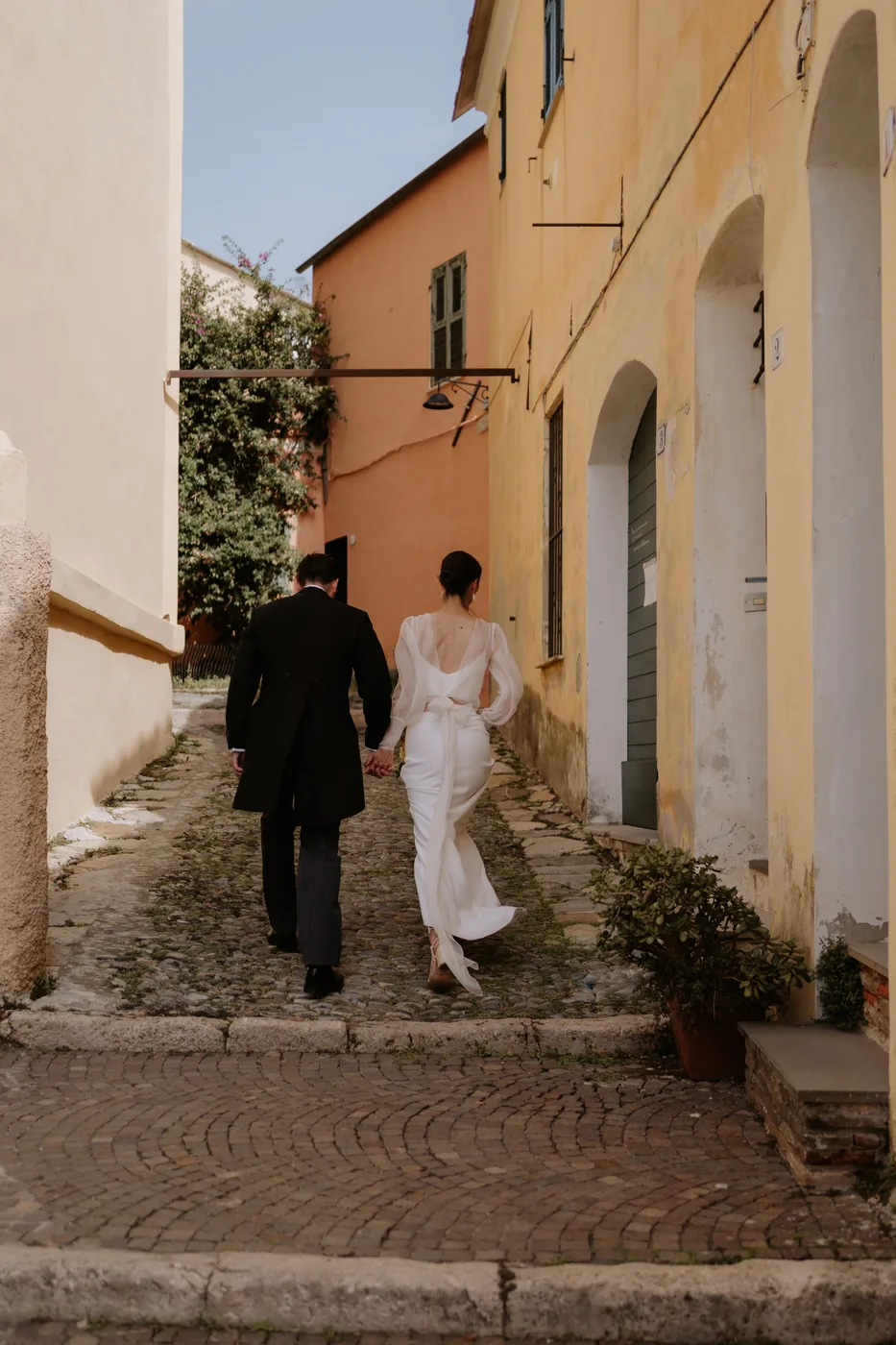 The couple climbing the steps between the village's pastel houses