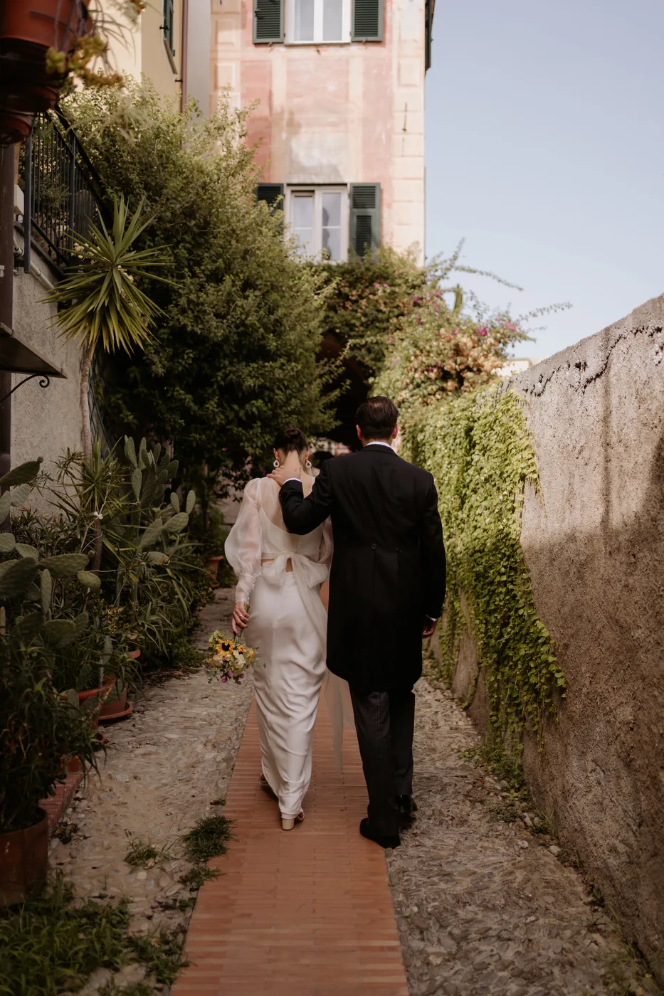 The couple walking hand in hand in a green lane in Cervo