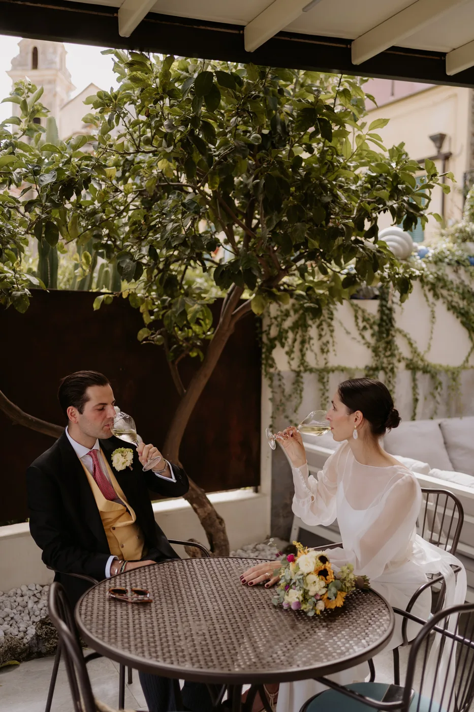 The couple toasting at a small table in the garden of Locanda del Cavaliere