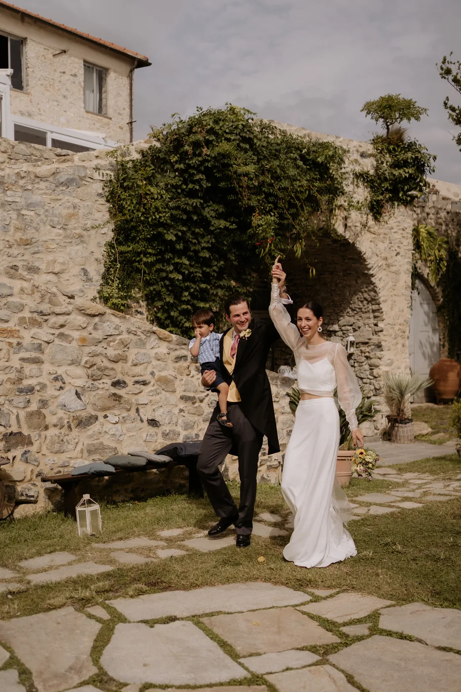 The couple celebrating with arms raised in the garden
