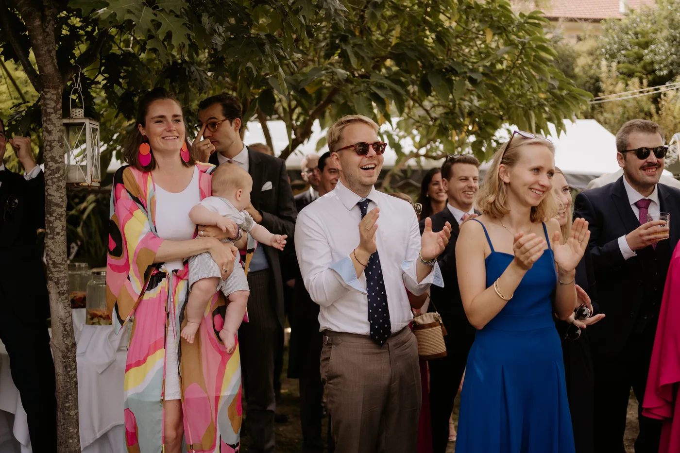Guests applauding under the garden trees