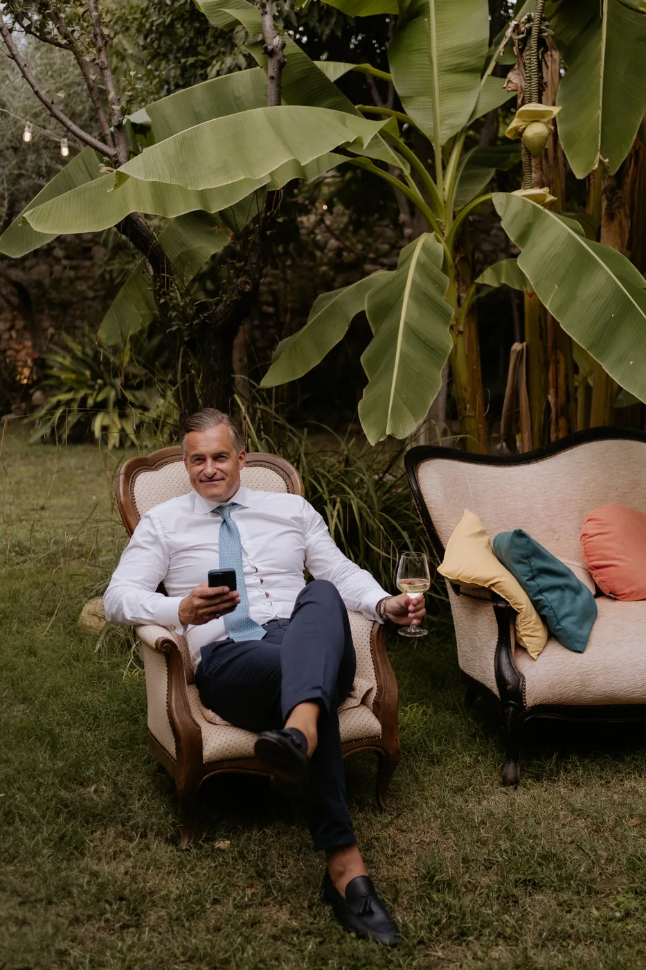 A guest relaxing in a vintage armchair among the subtropical plants