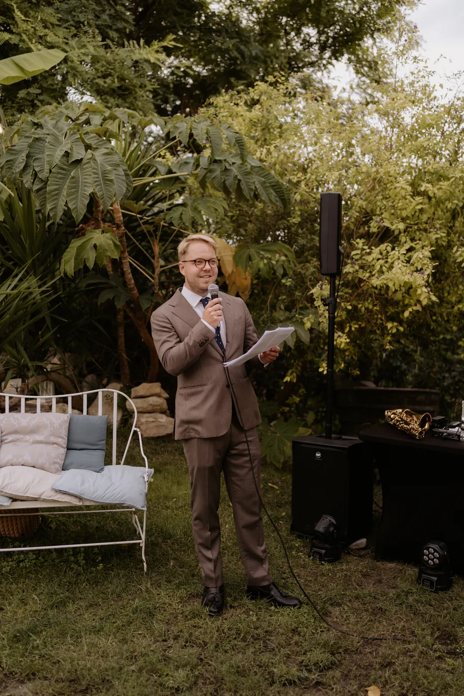 A guest giving a speech into the microphone in the garden