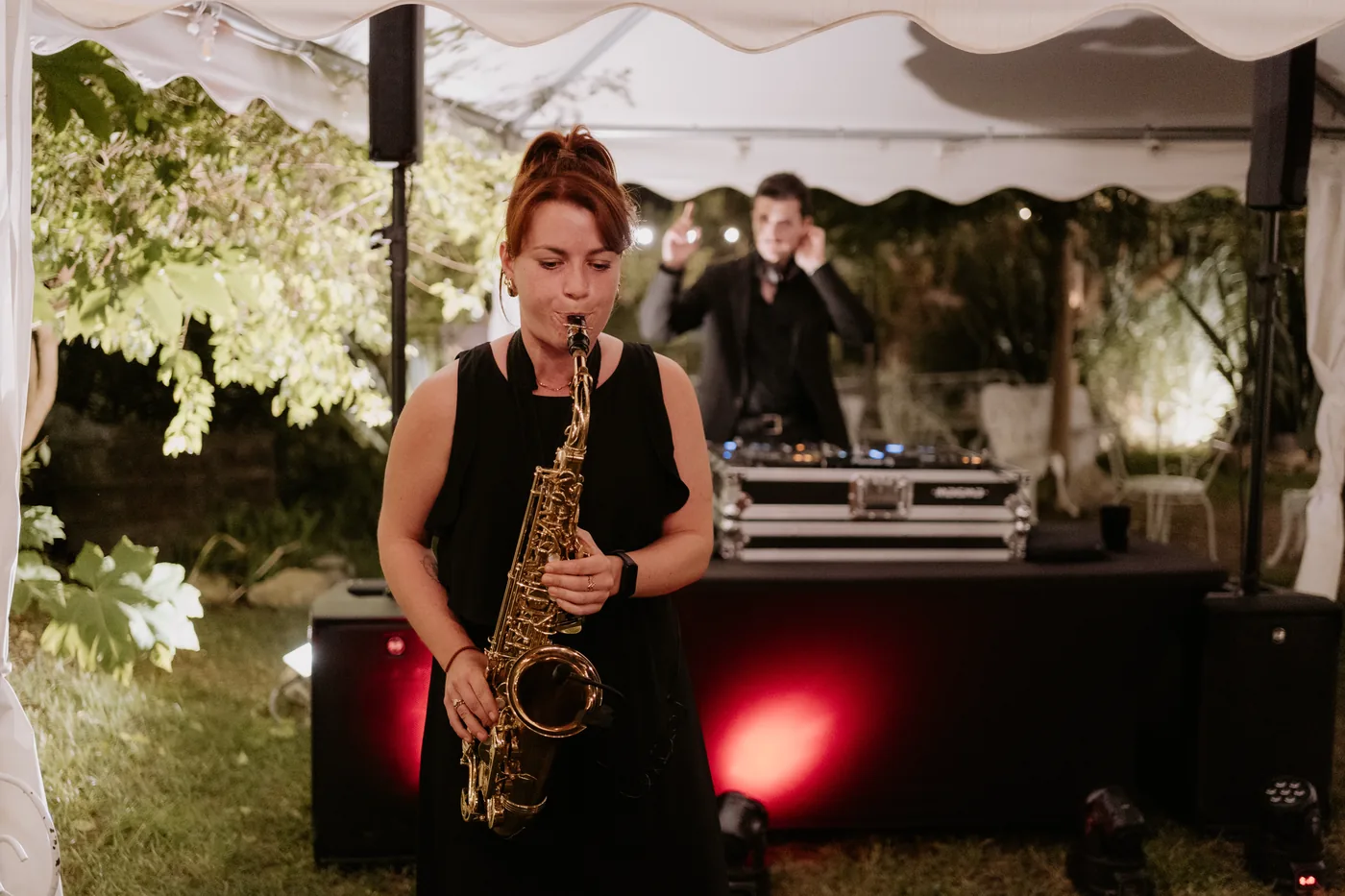 A saxophonist playing next to the DJ booth