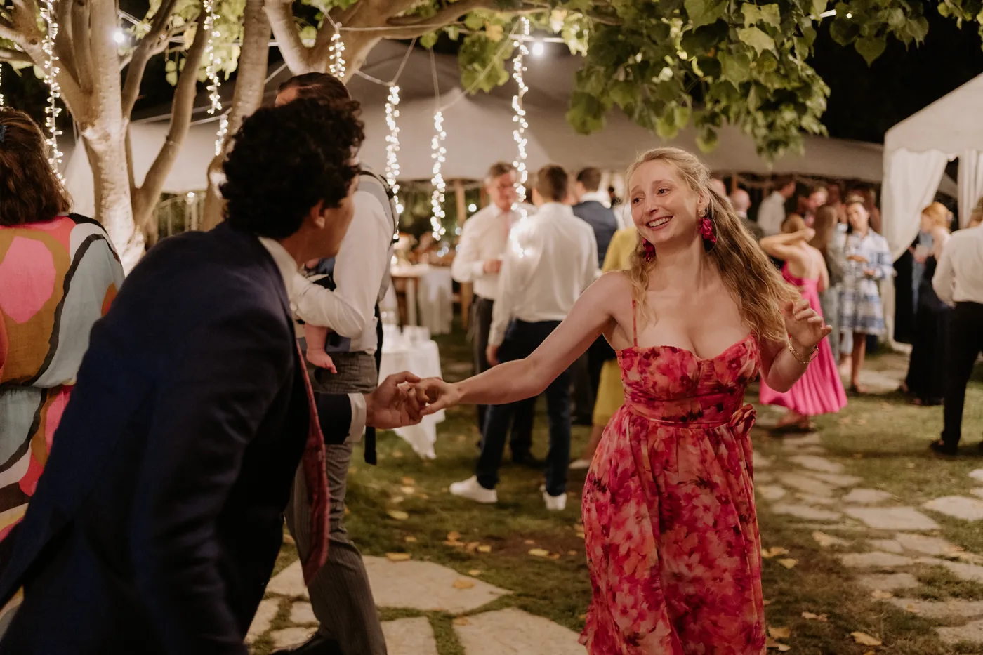 A guest in pink dancing with a friend in the garden