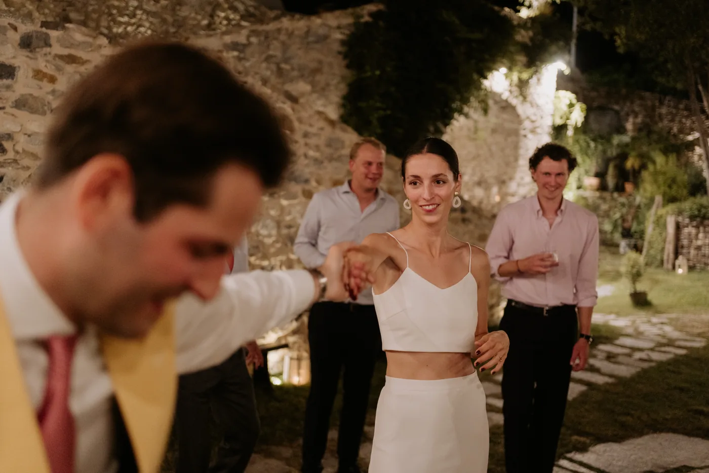 The groom laughing as he dances while the bride dances behind him