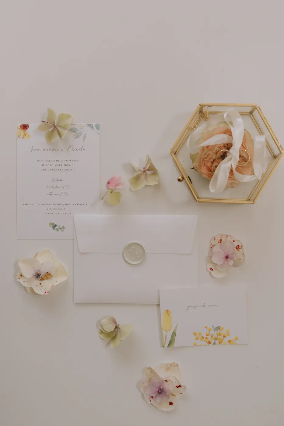 Invitations and paper flowers from Francesca and Nicolò's wedding laid out on the table