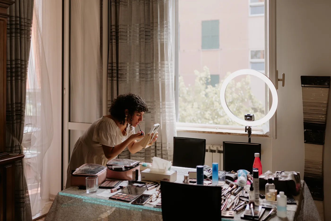 The makeup artist setting out her tools by the window