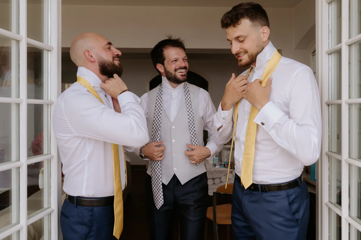 The groom and his friends adjusting their yellow ties