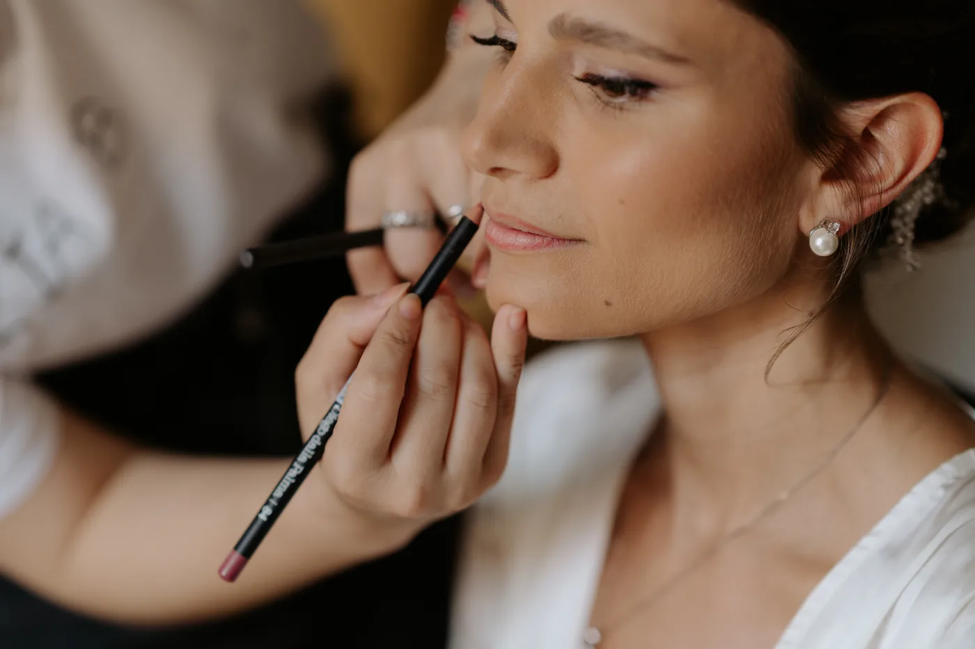 The bride having her lip makeup touched up