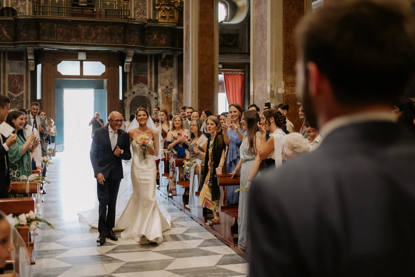 The bride walking down the aisle toward the waiting groom