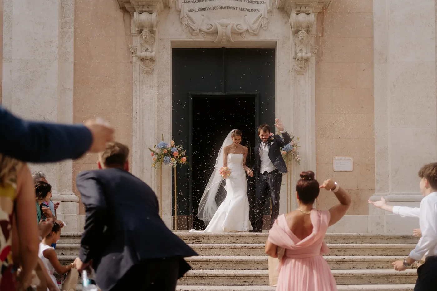 The couple leaving the church, showered by their guests