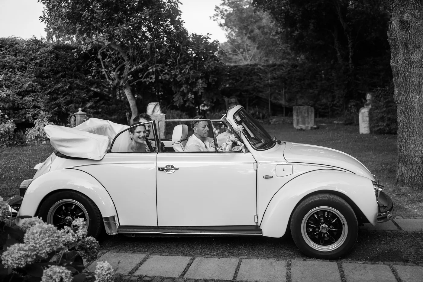 The couple in the white convertible Beetle, in black and white