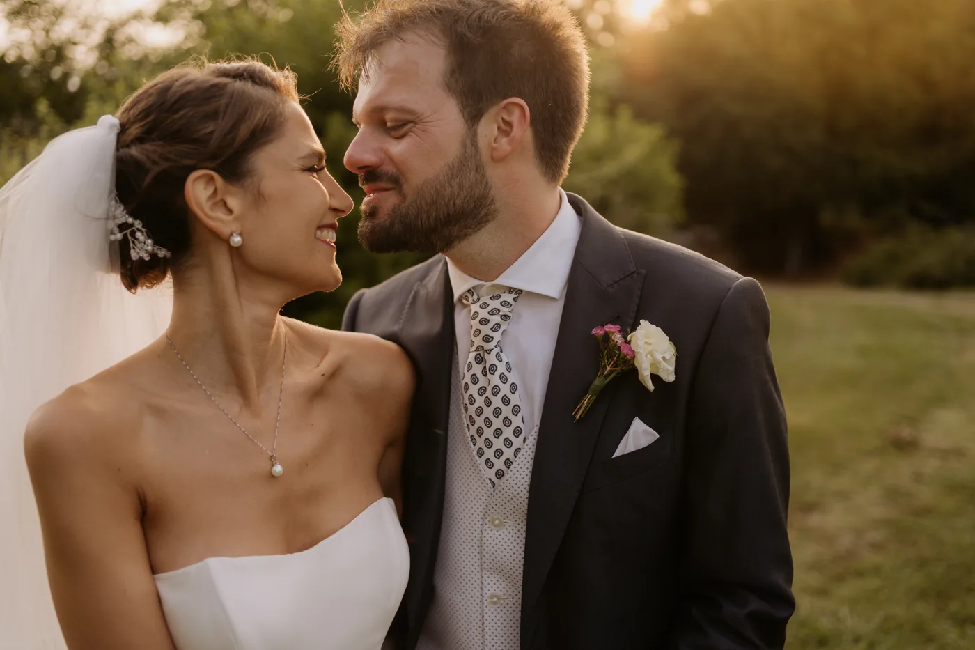 The couple smiling close together in the golden sunset light