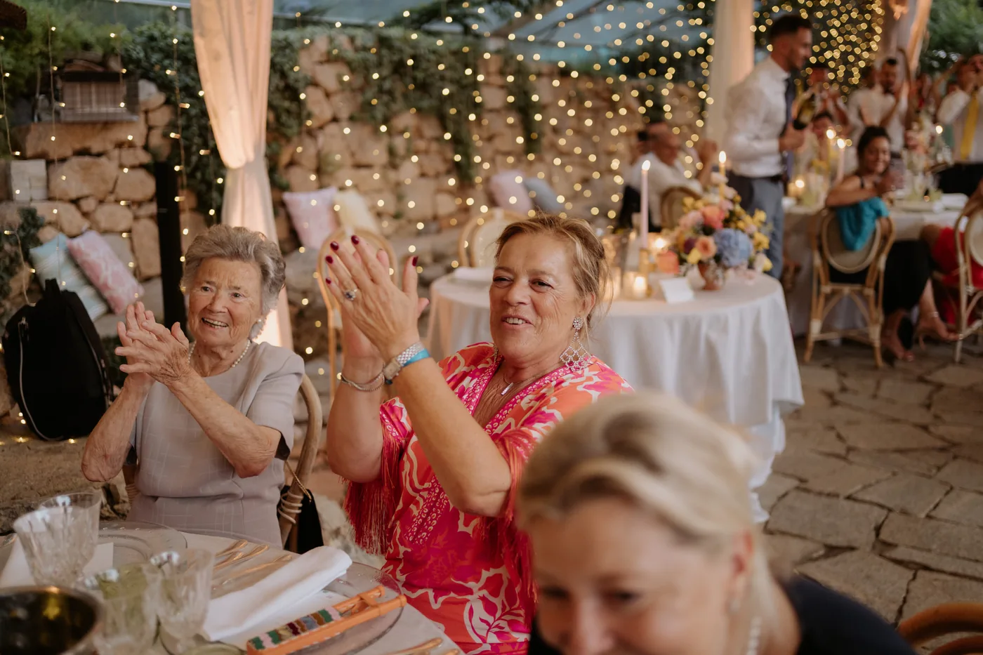 Two guests smiling and applauding during dinner