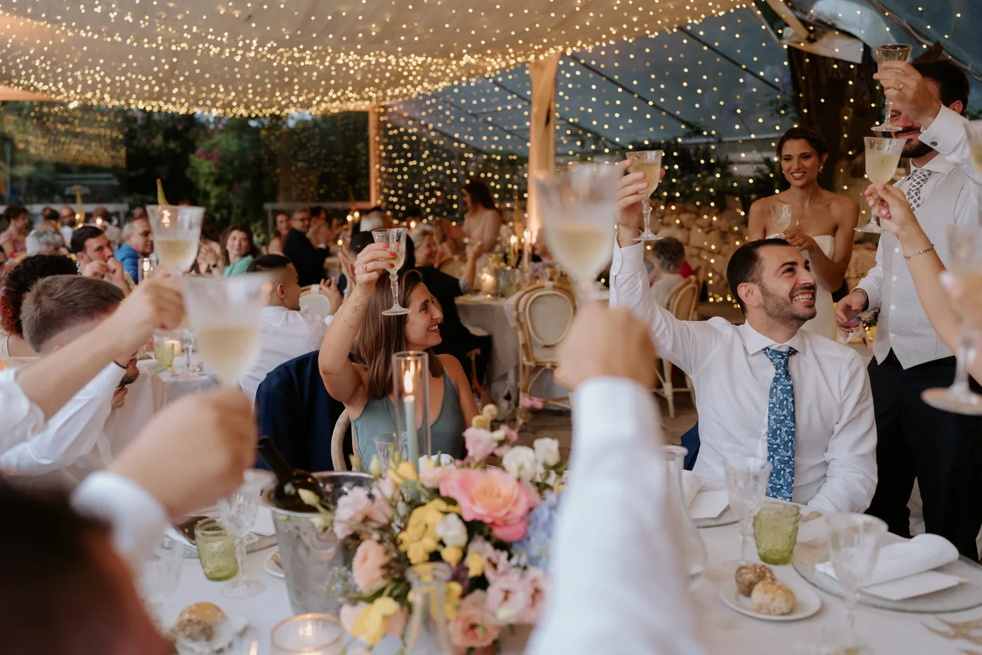 Guests toasting with their glasses raised above the tables