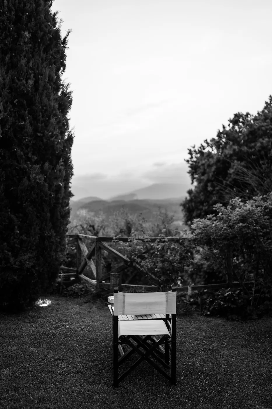 A director's chair in the garden overlooking the hills, in black and white