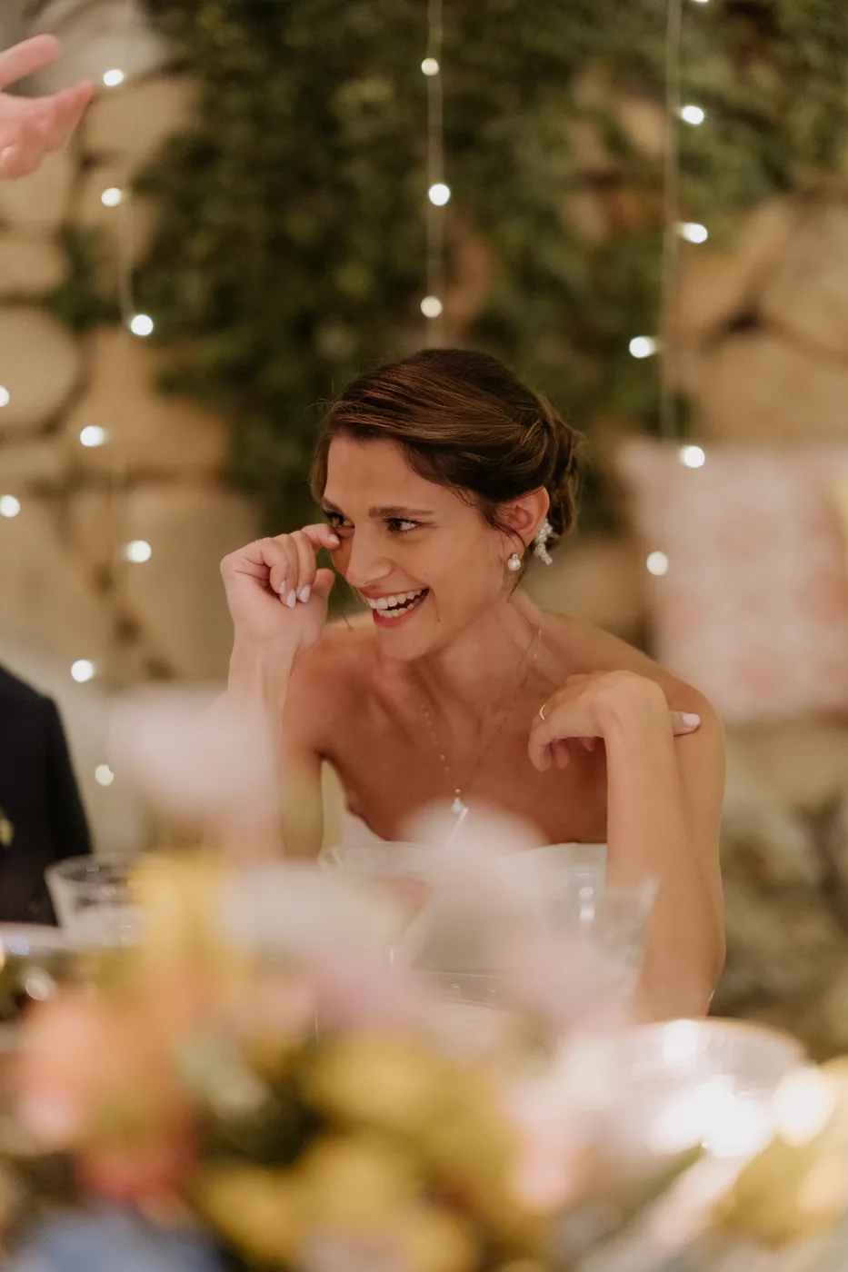 The bride wiping away a happy tear during dinner