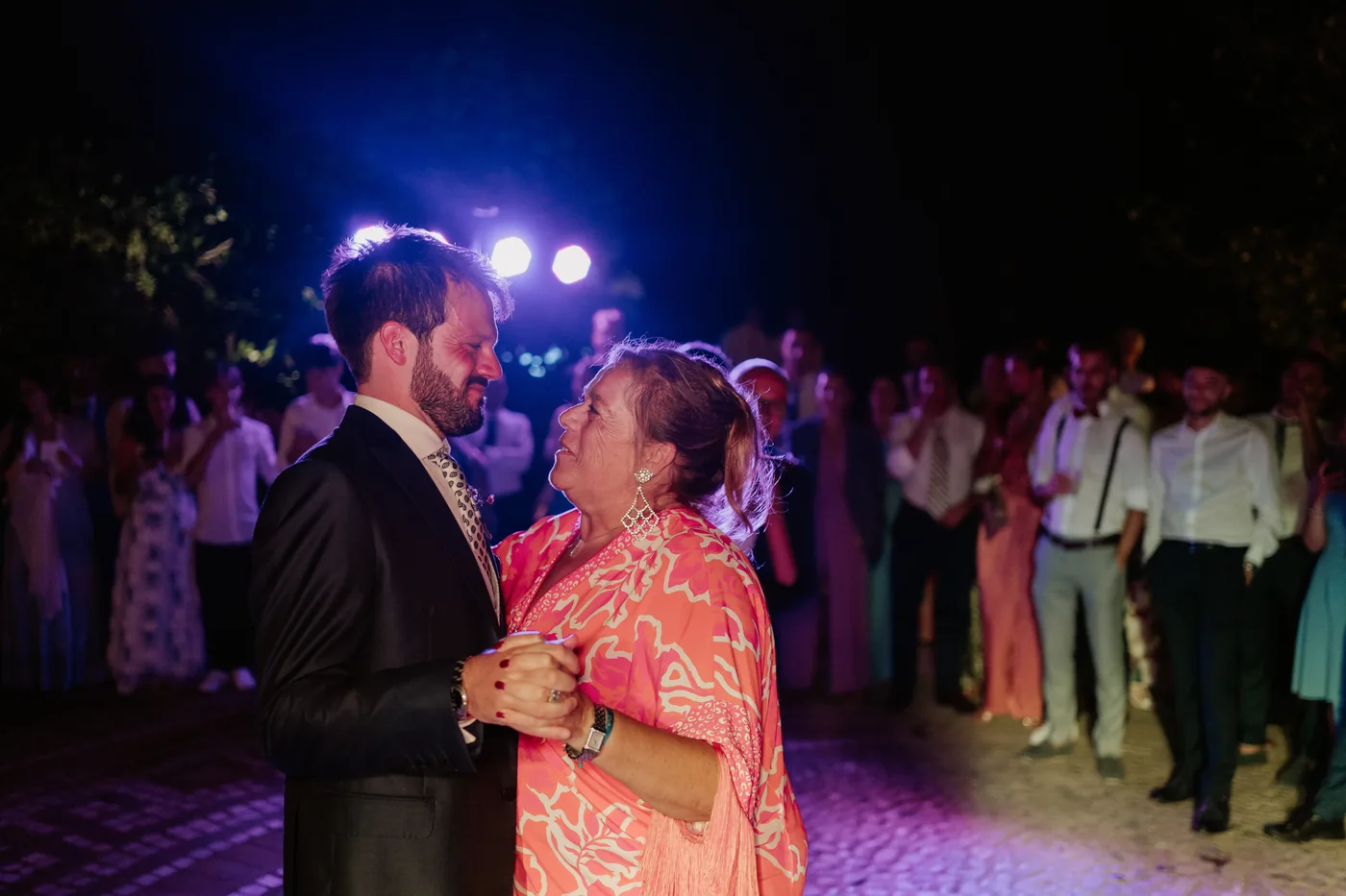 The groom dancing with a guest in a pink dress