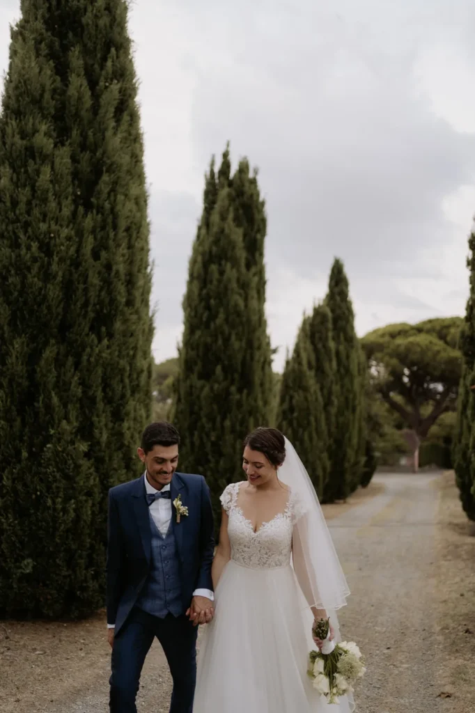 The couple smiling as they stroll along the cypress avenue