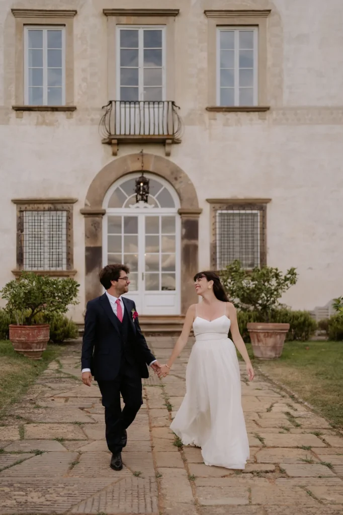 The couple walking in front of the facade of Villa Buonvisi